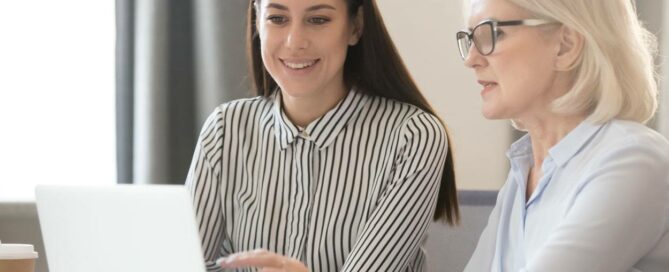 Confident experienced female employees share information with young worker